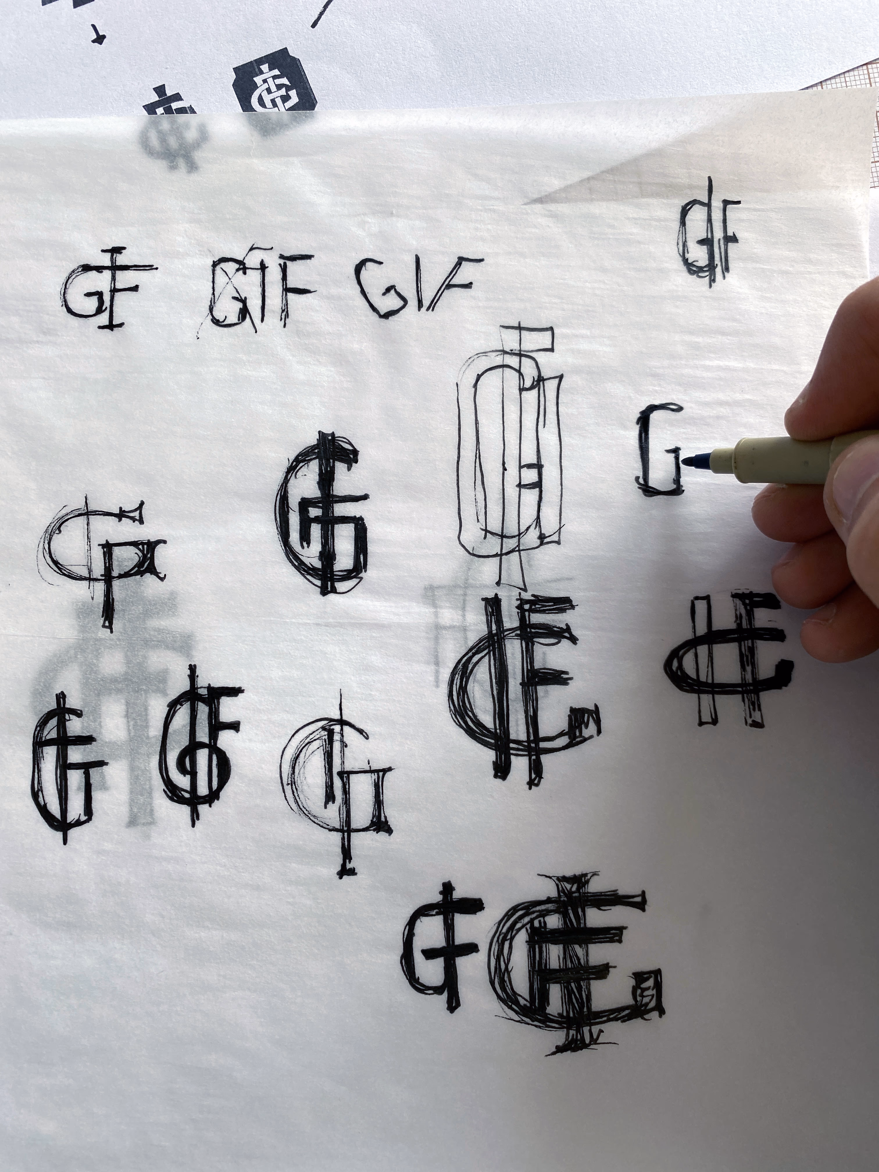 Estudos de lettering à mão do monograma GIF da General Iron Fittings em papel manteiga