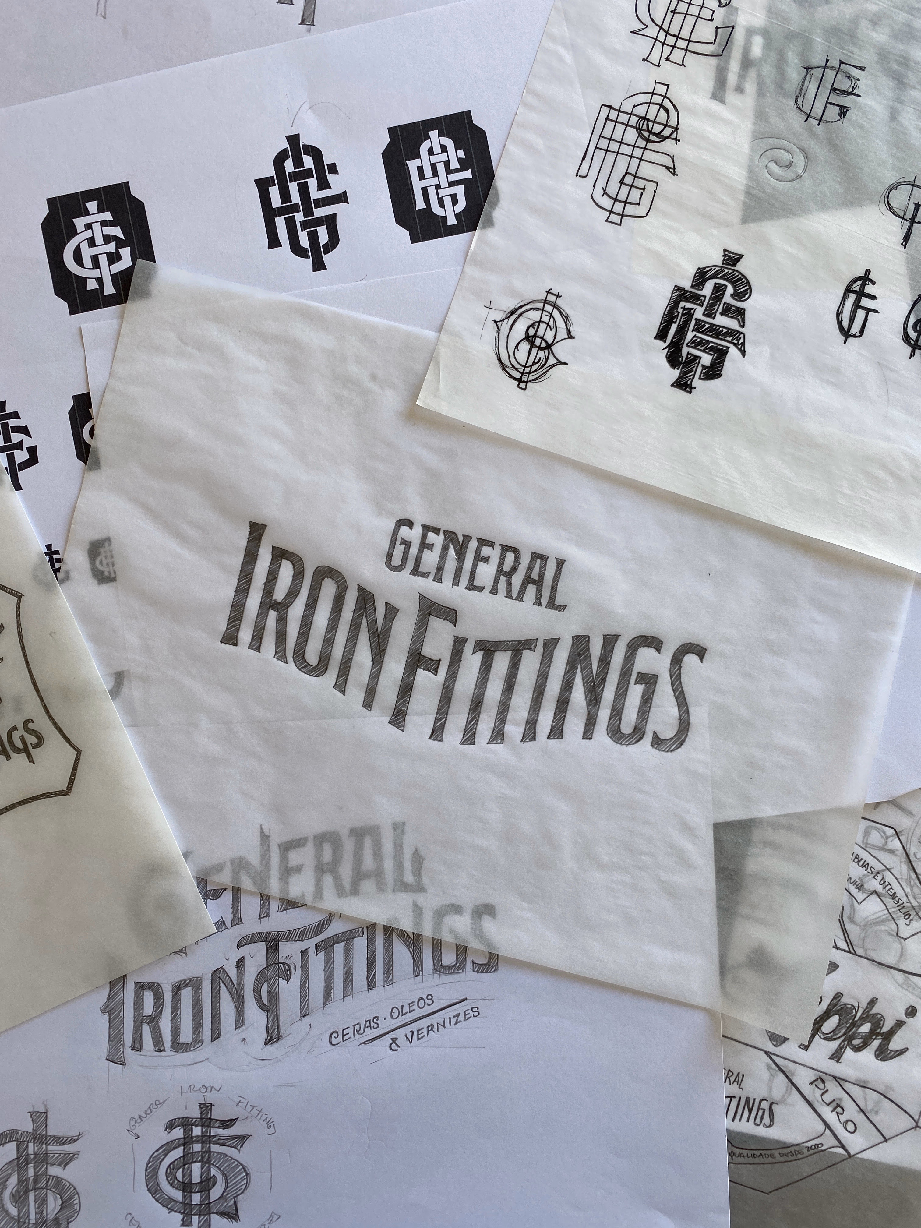 Estudos de lettering e monograma General Iron Fittings desenhados à mão em papéis de seda
