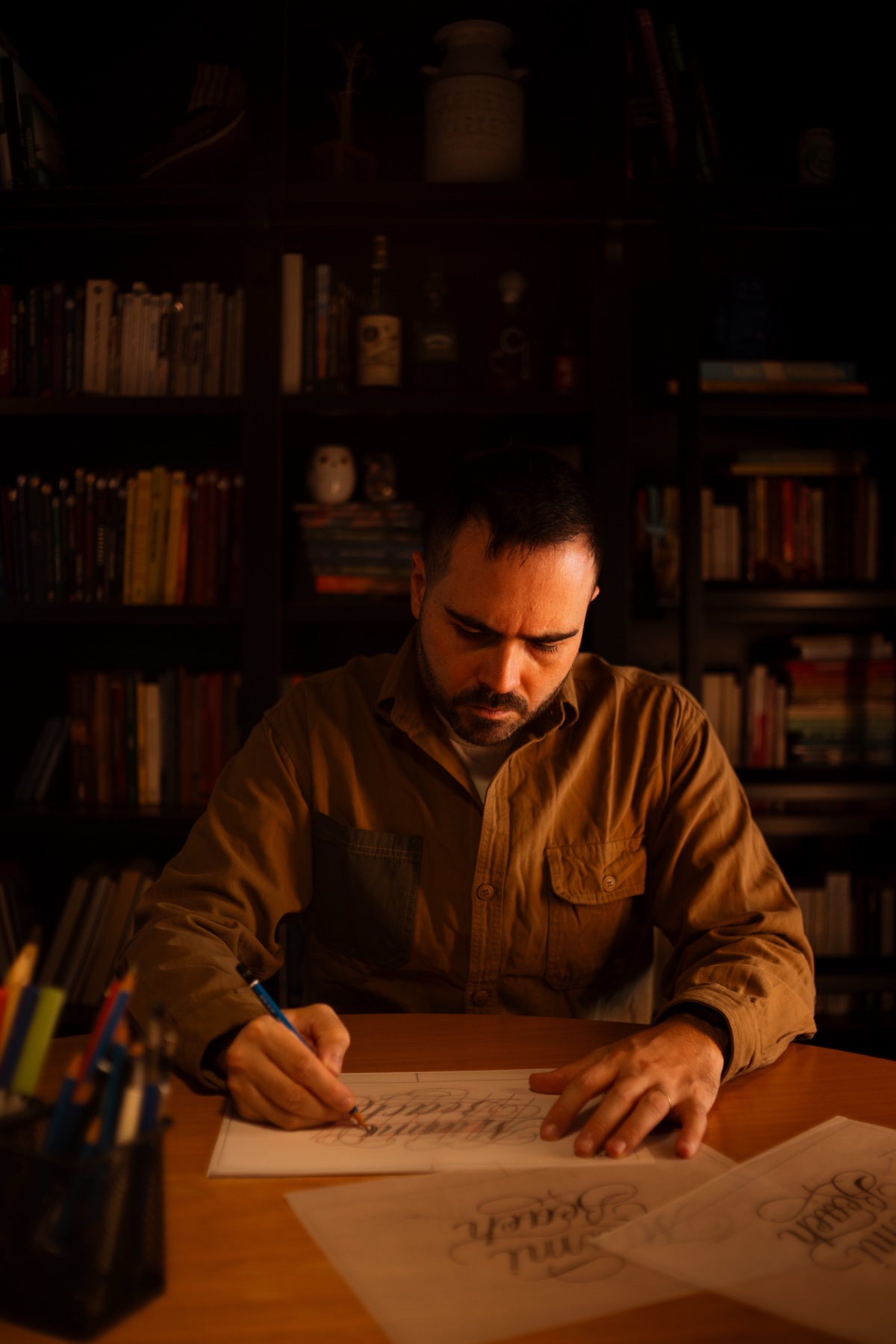 Victor Tognollo desenhando lettering no estúdio